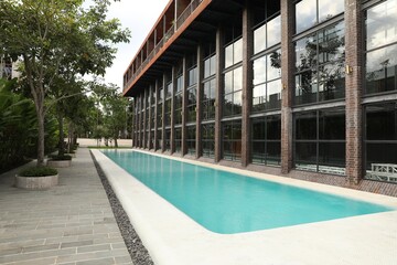 Outdoor swimming pool and green plants near building at luxury resort