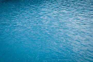 Clear water with ripples in outdoor swimming pool, closeup