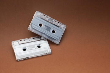 Audio cassettes with magnetic tapes on brown background. Space for text