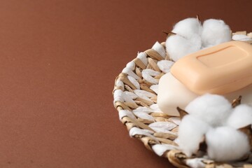 Soap bars and cotton flowers on brown background, closeup. Space for text