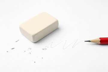 Pencil, eraser, doodle and scraps on white background, closeup