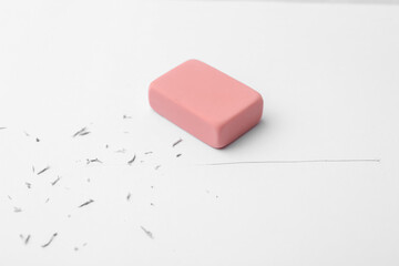 Eraser on paper sheet with pencil strokes, closeup