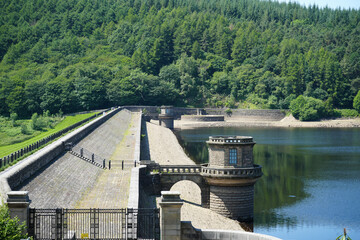 Peak District, Derbyshire, England - June 20 2025: Tranquil view of a stone dam in a forested area...