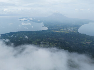 Aerial view of lush landscape and volcanic island under cloudy sky