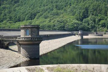 Ladybower, Derbyshire, England - June 20 2025: A reservoir featuring a stone dam with cylindrical...