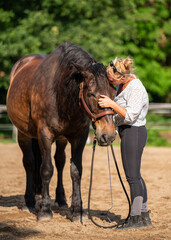 Heartwarming moment between girl and horse. Young woman kisses her horse with tenderness as animal...