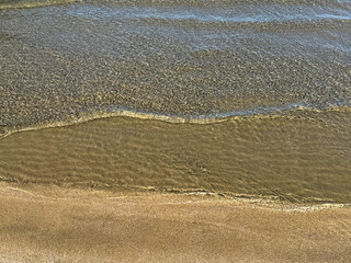 Gentle waves at the sand beach.