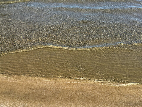 Gentle waves at the sand beach.