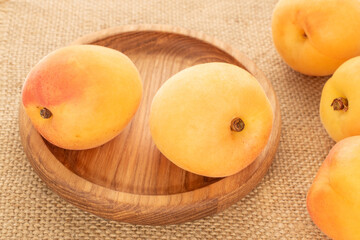Sweet organic apricots isolated on jute cloth, macro.