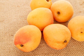Sweet organic apricots isolated on jute cloth, macro.