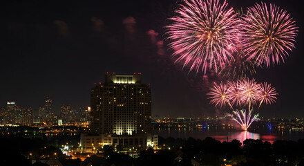 Naklejka premium Fireworks bursting over city skyline on 4th of July night