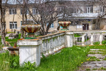 Decaying soviet era stone planters in overgrown garden setting