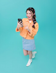Top view Happy smiling young asian woman using mobile phone isolated on blue background. teen social media communication online.