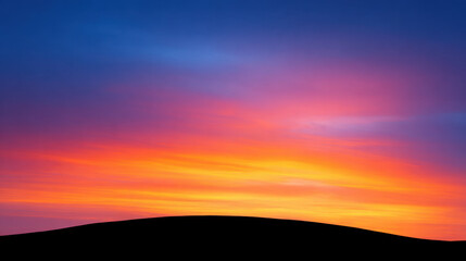 Obraz premium Sunset sky with vibrant orange and purple colors above dark hill silhouette creating peaceful and dramatic landscape scene