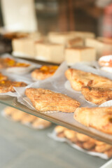 Golden puff pastries and cakes displayed in bakery window