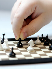 Macro mini chess and kid's hand, intellectual game.
