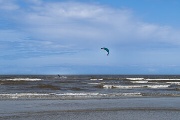 Man Kitesurfing in the Ocean with Colorful Kite in the Sky – Extreme Water Sport, Windy Day and...