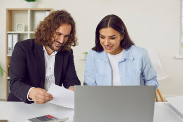 Male accountant or auditor meeting with female client. Two happy people sitting at office desk and...