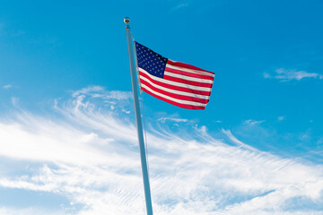 Flag of the USA. National waving flag of united states on blue sky. Independence day. Patriotic symbol. American Flag for Memorial Day or 4th of July. American flag. Day of independence