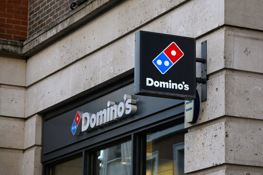 London. UK - April 1, 2025; Sign with logo at Domino's fast food pizza store in closeup