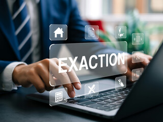 A professional business photo of exaction preparation and financial analysis. In the foreground, hands are typing on a white laptop keyboard.