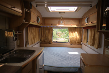 Inside of a mobile home. Large bed and furniture in a camper