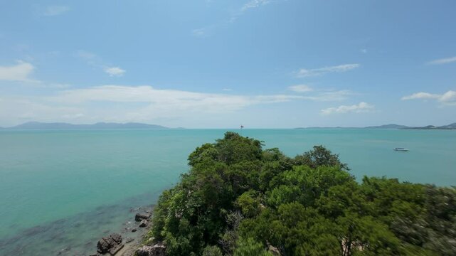 Fast Aerial Approach Toward Thai Flag on Hilltop Surrounded by Lush Trees Overlooking Turquoise Sea on Koh Samui for Patriotic Island Exploration Concept