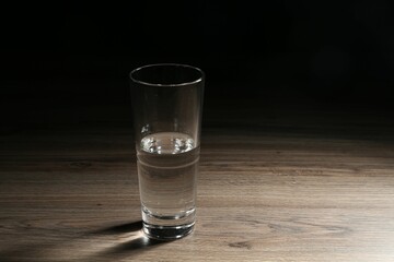 Fresh water in glass on wooden table