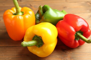 Ripe colorful bell peppers on wooden table, closeup