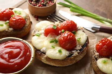 Tasty stuffed mushrooms served on wooden table, closeup