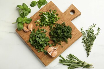 Different herbs and spices on white table, flat lay