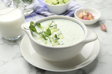 Tasty cucumber soup with dill, microgreens and ingredients on white marble table, closeup
