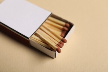 Matches in box on beige background, closeup. Mockup for design