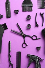 Different hairdresser's tools on violet background, flat lay