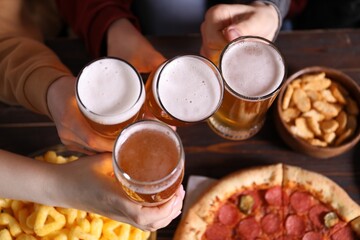Friends with beer and snacks at wooden table, top view