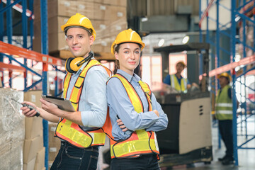 Confidence caucasian man, woman staff worker wear safety helmets, vest show teamwork collaborate, cooperation in logistics inventory operation. show success, efficiency in modern warehouse management.