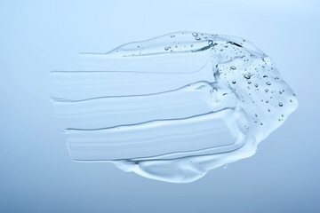 A smear of gel serum texture on a blue background.