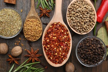 Different aromatic spices on wooden table, flat lay