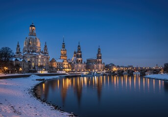 Obraz premium Dresden city at night, buildings reflected on the Elbe River, with a twilight sky.