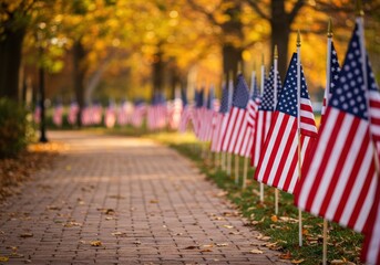 Rows of american flags stand tall along a brick pathway in a picturesque fall setting.