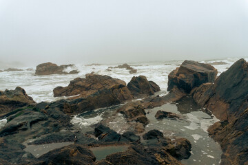 Misty Portuguese winter coastline with rocky shores and melancholic atmosphere