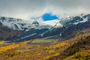 Majestic snow-covered mountains with rocks and trees in Kyrgyzstan
