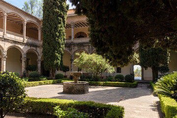 Cloister with stone fountain and cypress trees in santes creus monastery