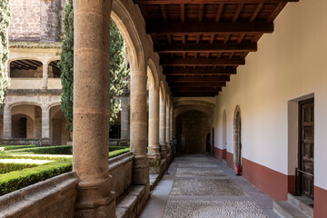 Cloister of the monastery of yuste showing stone columns and wooden roof