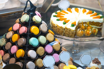 Colorful display of macarons and cake in a bakery showcase