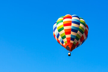 Colorful hot air balloon launching in blue sky