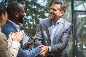 diverse male partners hake hands get acquainted greeting at meeting