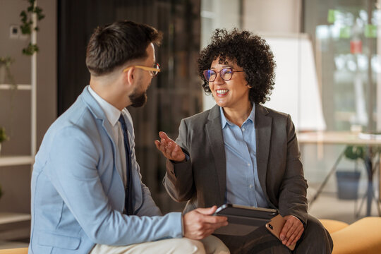mature african american woman and caucasian man use digital tablet