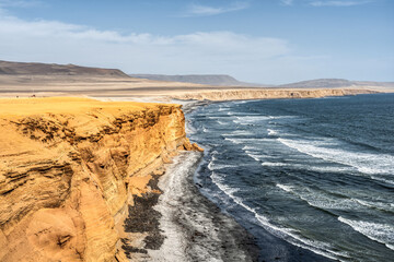 Dramatic Pacific ocean landscape with sandstone coastal cliffs in Paracas National Reserve, Peru