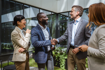 Happy black businessman and caucasian businessman shake hands